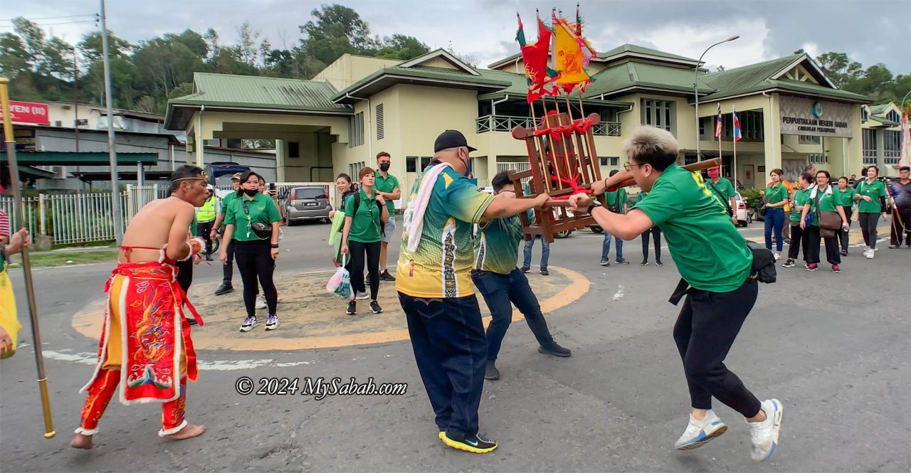 Followers trying to calm down the shaking sedan chair of deity